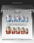 Frosted Cherry press-on nails in blue and gold glitter with red gem accents displayed in a clear packaging box