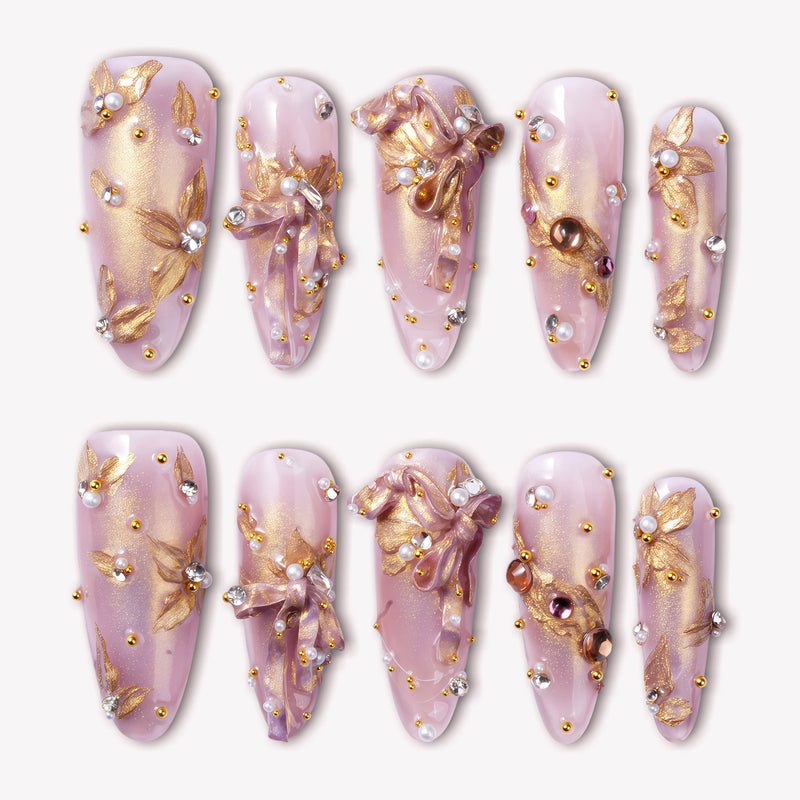 Gilded Petal Waltz press-on nails in soft lavender and gold with floral accents, pearls, and rhinestones arranged in a flat lay