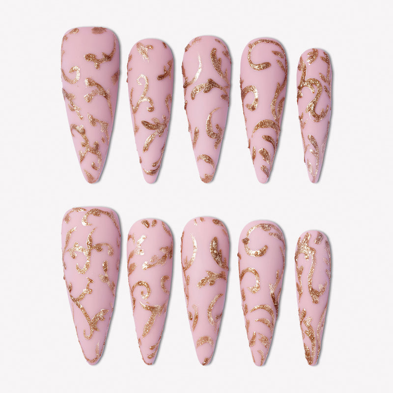 Gilded Petals press-on nails with soft pink bases and raised gold vine and petal patterns in a full set display
