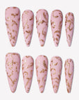 Gilded Petals press-on nails with soft pink bases and raised gold vine and petal patterns in a full set display