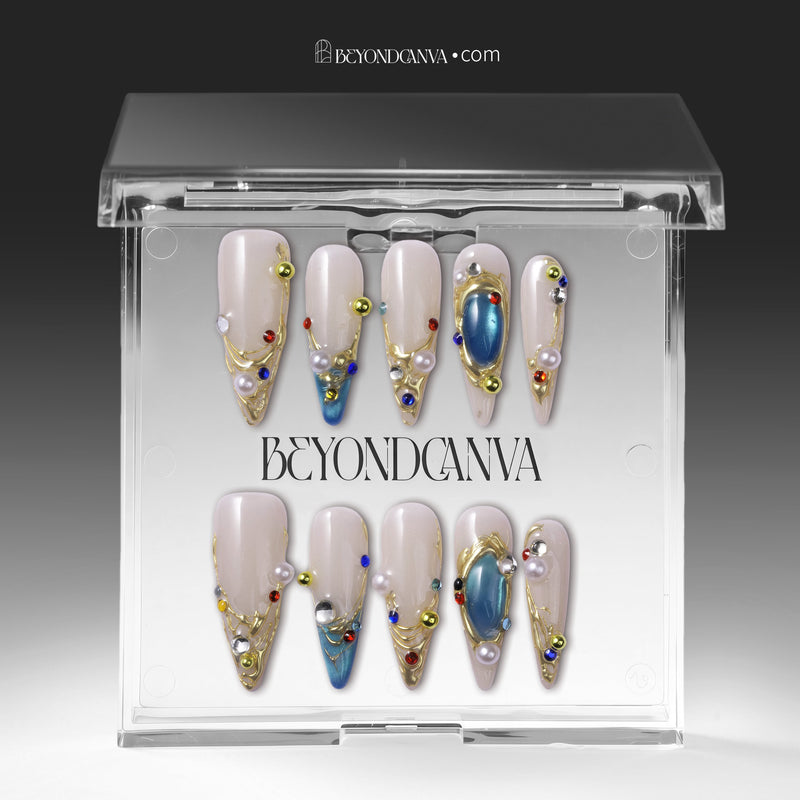 Gilded Relic Blue press-on nails displayed in clear packaging with blue gems, pearls, and gold accents