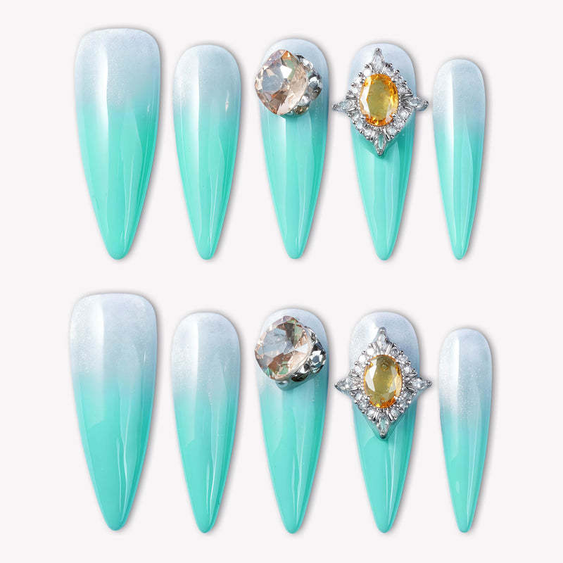 Flat lay of Glacier Jewel press-on nails with icy blue ombré and yellow crystal embellishments