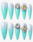 Flat lay of Glacier Jewel press-on nails with icy blue ombré and yellow crystal embellishments