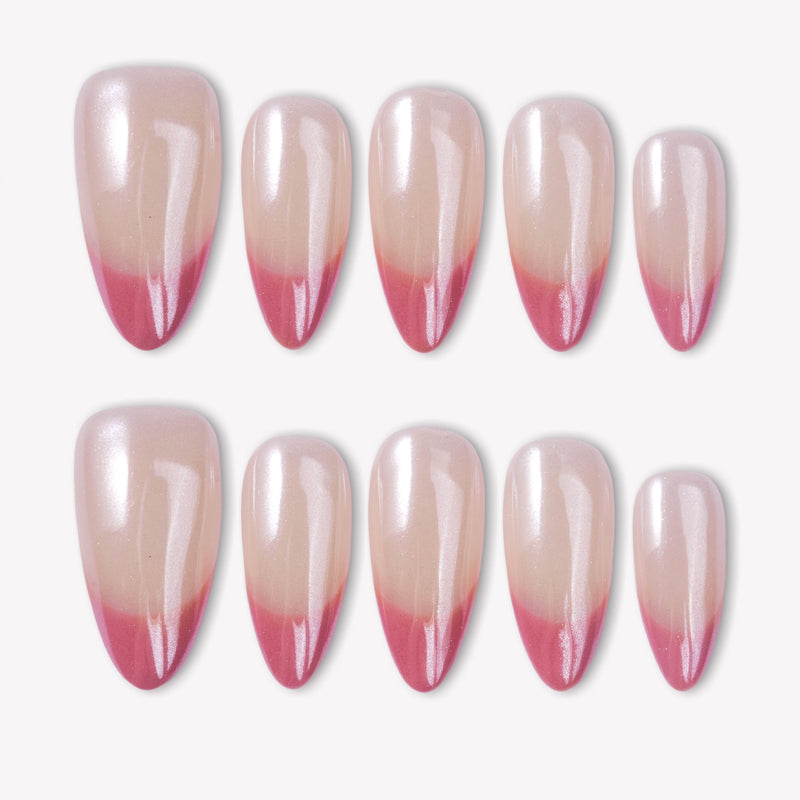 Glazed French press-on nails with pearly nude bases and glossy pink glitter French tips in a white flat lay