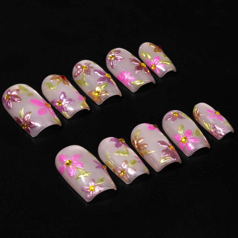 Golden Meadow press-on nails shown as floral decorated nail tips on a black background