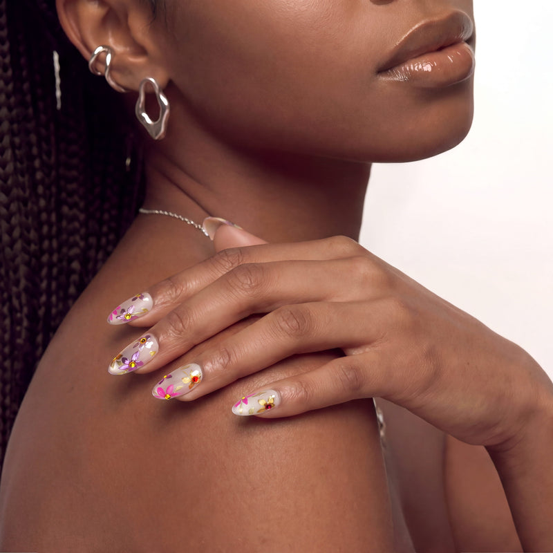 Angled view of a hand wearing pink floral cat-eye press-on nails