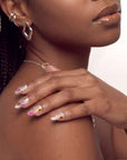 Angled view of a hand wearing pink floral cat-eye press-on nails