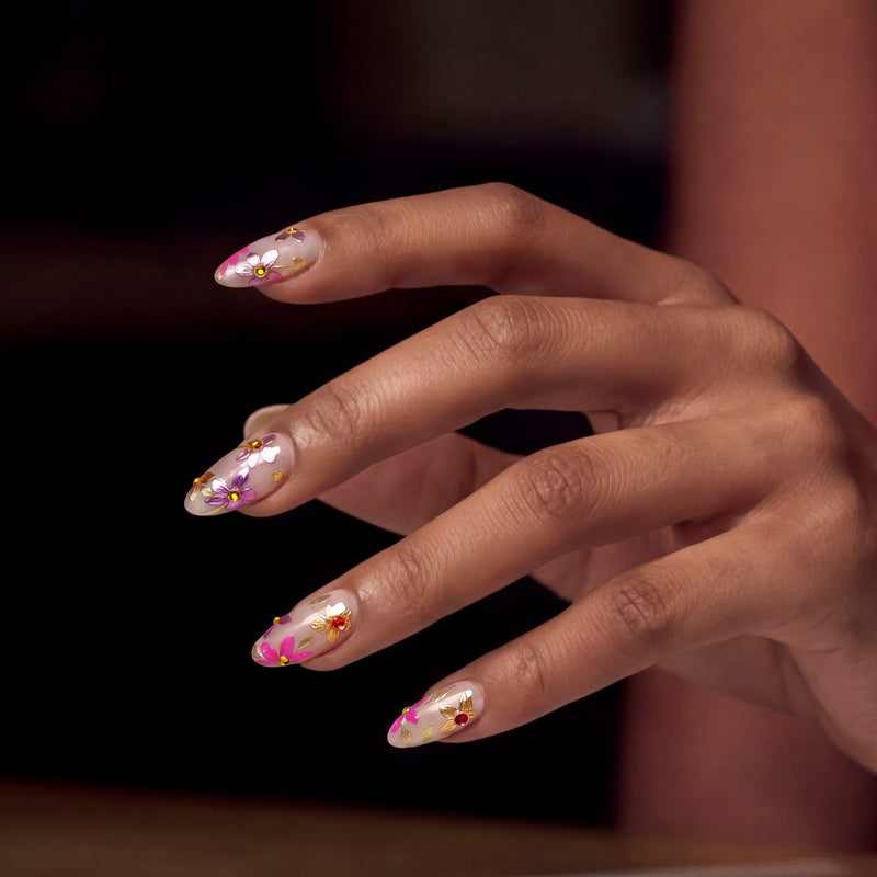 A hand wearing pink floral cat-eye press-on nails