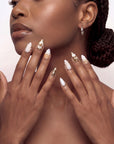 Portrait of a model wearing Golden Shell white and gold seashell press-on nails with pearl accents