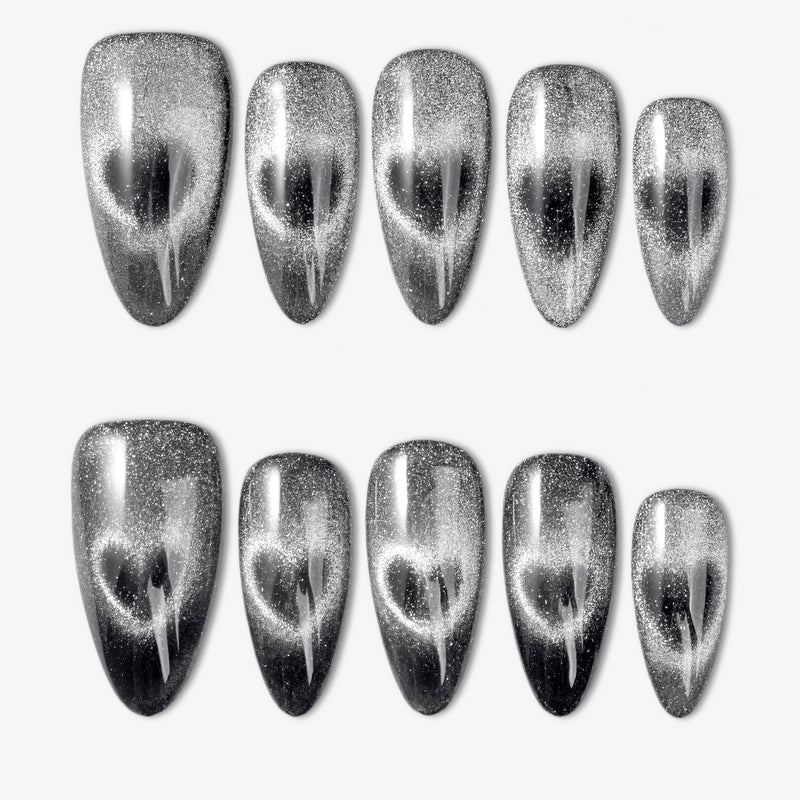 Gravity black and silver cat-eye glitter press-on nails with a glossy finish arranged in a white flat lay