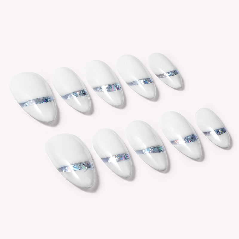 Diagonal flat lay of white press-on nails with iridescent chrome shimmer accents on a pale background.