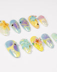 Angled flat lay of Iridescent Petals pastel iridescent nails with sculpted flowers, pearls and jewel accents