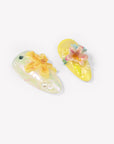 Close-up of two Iridescent Petals yellow press-on nails with raised pink and yellow flowers, pearls and gems