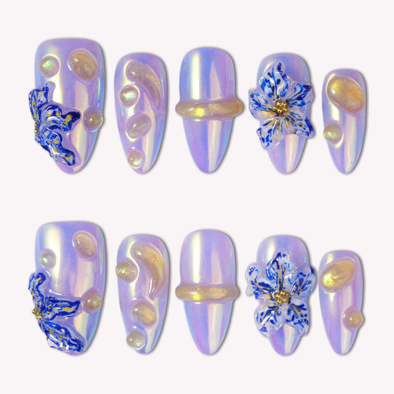 Iris Bloom iridescent purple press-on nails with raised blue flowers, gold accents and pearl-like details
