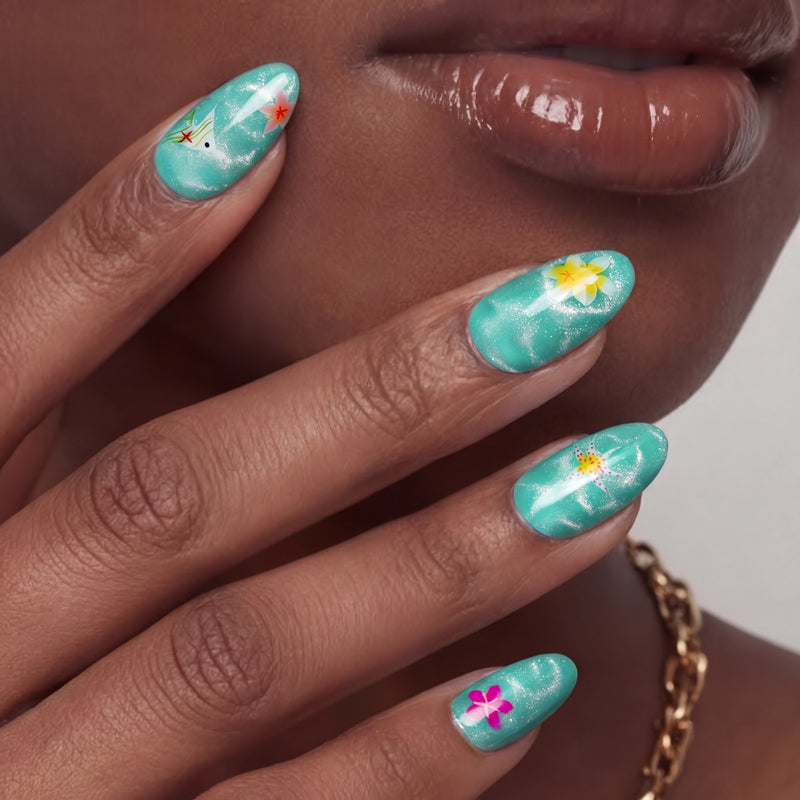 Close-up of a hand model wearing turquoise almond press-on nails with yellow and pink floral accents