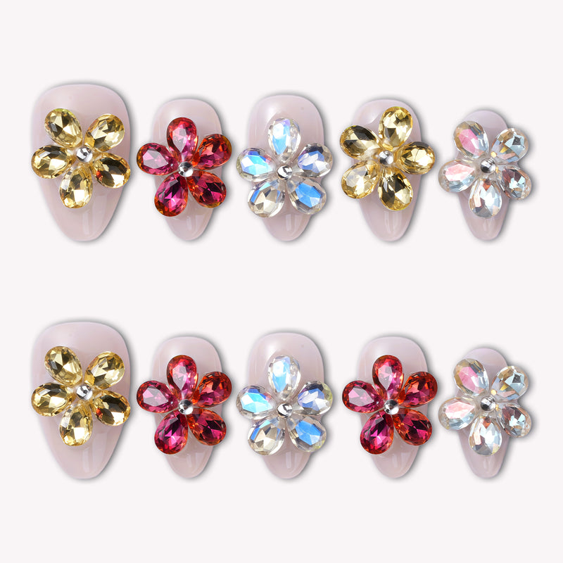 Two rows of jeweled floral press-on nails displayed on a white background.