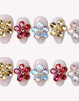 Two rows of jeweled floral press-on nails displayed on a white background.