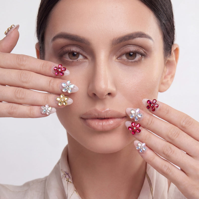 Model close-up with jeweled floral press-on nails framing her face.