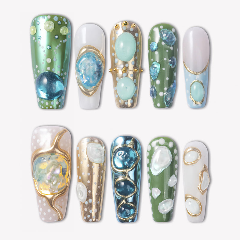 Jungle Relic green, blue, ivory and gold press-on nails with raised translucent gemstone details in a flat lay