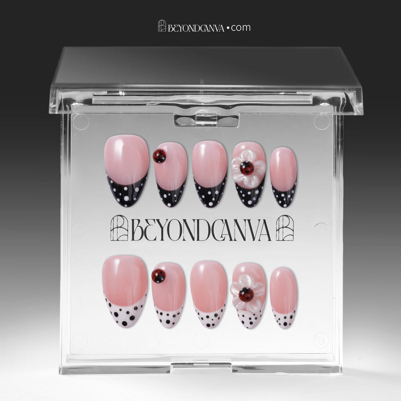 Packaging display of Ladybug Garden press-on nails with pink bases, black and white polka dot French tips, red ladybugs, and white flower charms in a clear BeyondCanva case