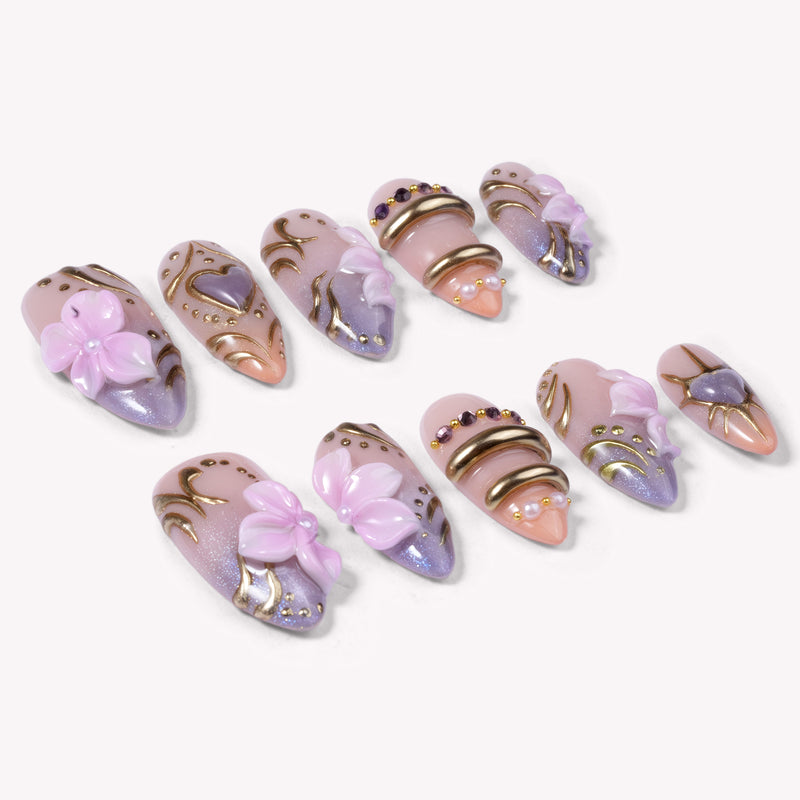 Lavender Lyric handmade press on nails arranged in a white flat lay showing the full nail set with lavender florals and gold accents