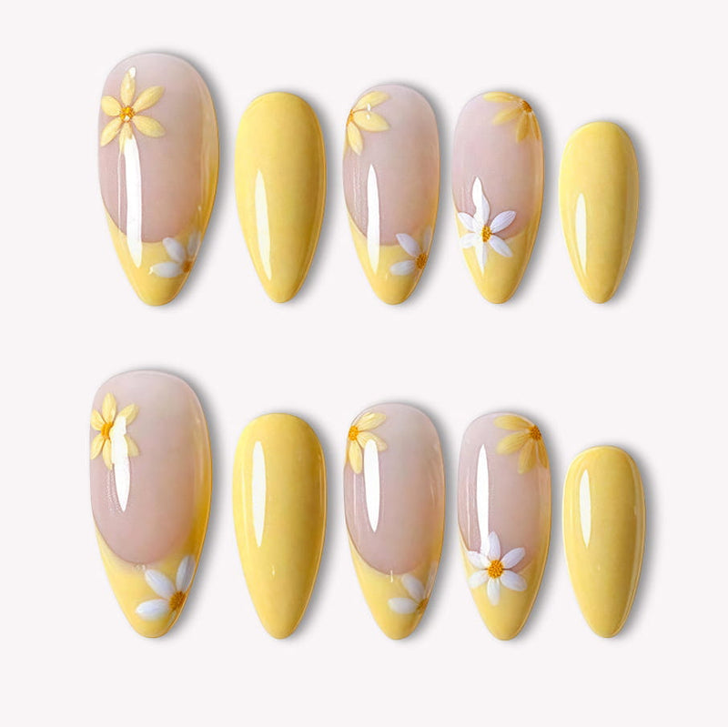Lemon Bloom yellow press-on nails with nude bases, white daisy flowers and glossy yellow tips