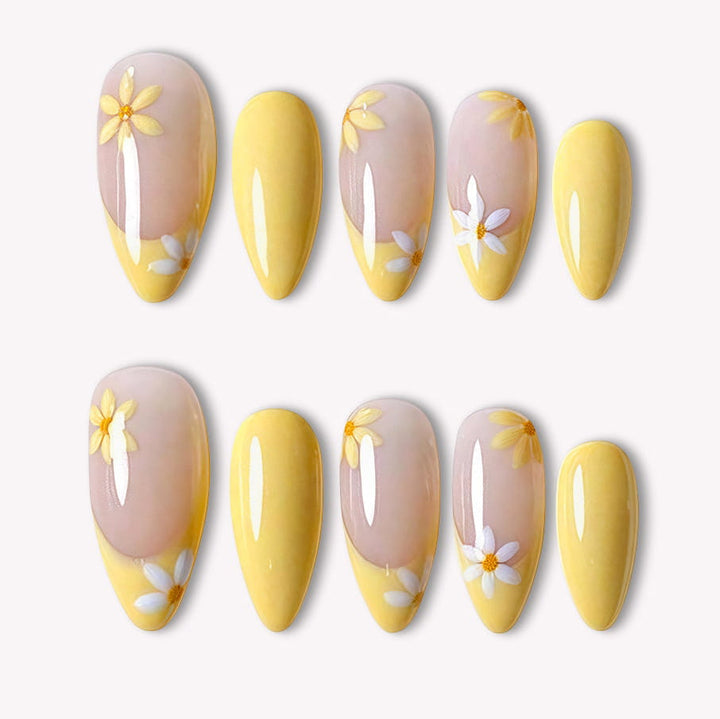 Lemon Bloom yellow press-on nails with nude bases, white daisy flowers and glossy yellow tips