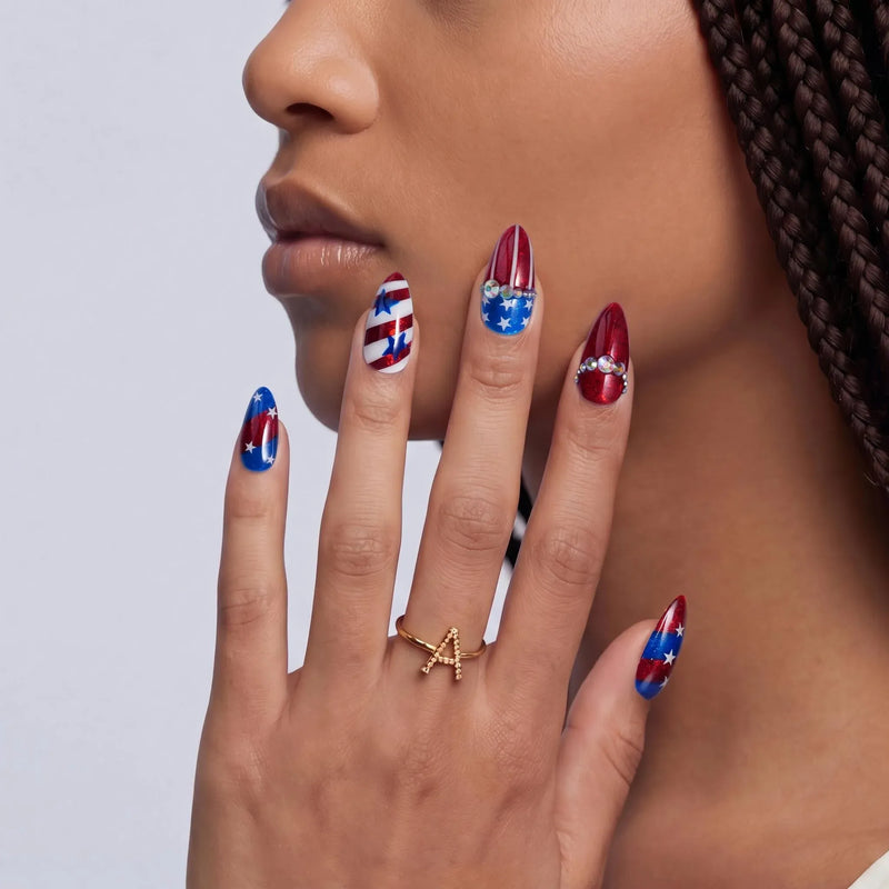 Hand model wearing red, white, and blue American flag press-on nails with star accents.
