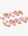 Angled flat lay of Liquid Gold pink and white press-on nails with raised rose gold frames and crystal accents