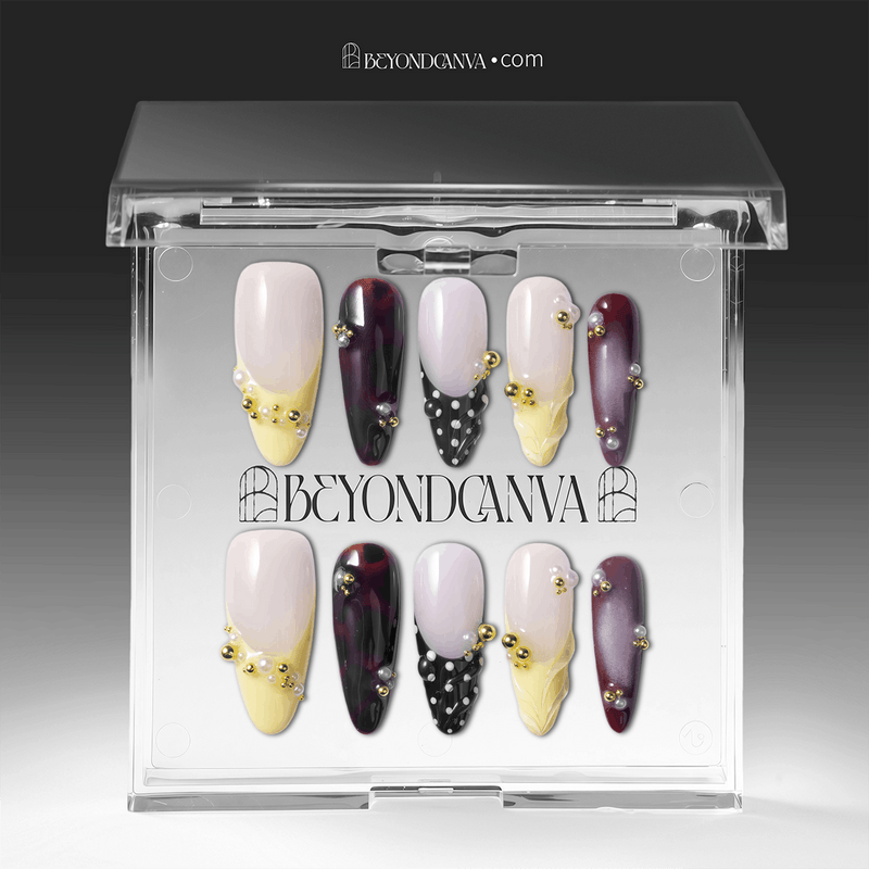 Packaging display of Lunar Velvet press-on nails in a clear Beyondcanva case with pale yellow tips, burgundy cat eye polish, black dotted lattice, pearls, and gold beads