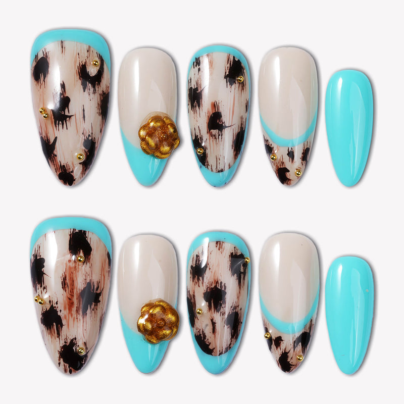 Flat lay of Luxe Savannah press-on nail swatches with turquoise tips, cream bases, black animal print, and gold flower accents