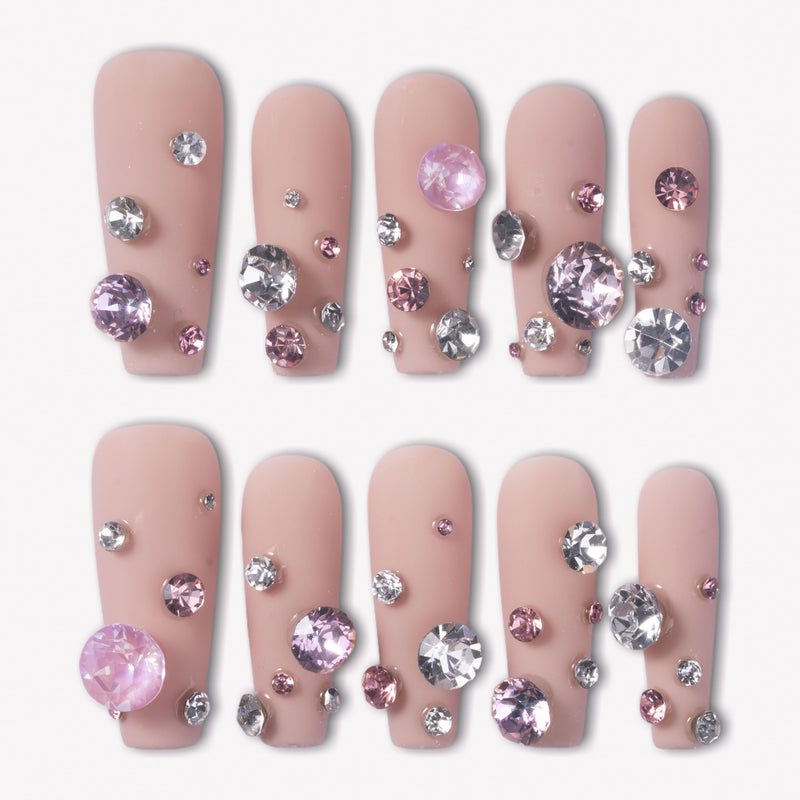 Luxurious Treasure press-on nails with nude pink square bases covered in large pink and clear rhinestone gems for a jeweled look