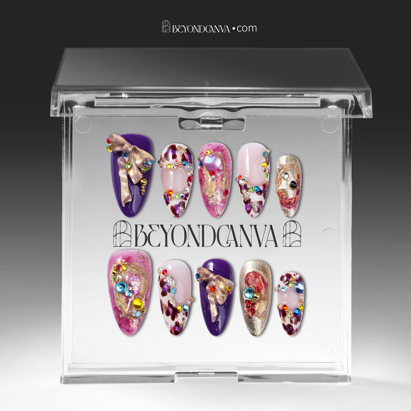 Set of 10 luxury handmade press-on nails in a clear acrylic case, featuring ornate 3D gold accents, multi-colored rhinestones in turquoise ruby and sapphire blue, and purple and pink almond-shaped nail art