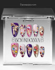 Set of 10 luxury handmade press-on nails in a clear acrylic case, featuring ornate 3D gold accents, multi-colored rhinestones in turquoise ruby and sapphire blue, and purple and pink almond-shaped nail art