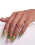 Matcha & Boba handmade press on nails shown on the back of a hand with green fruit and swirl accents