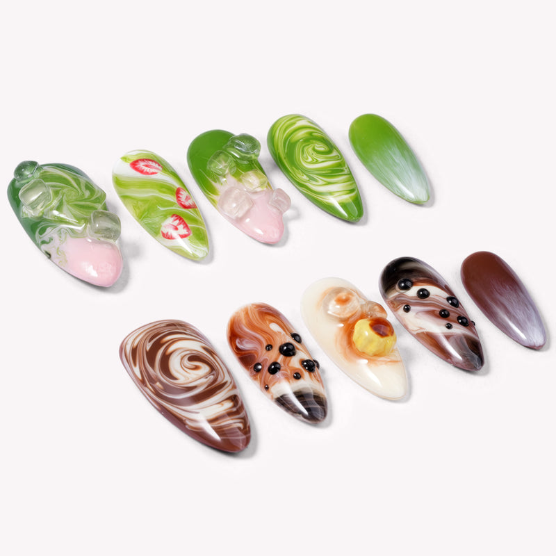 Matcha &amp; Boba handmade press on nails arranged in a white flat lay with green and brown swirled nail designs