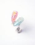 Detail display of Mermaid Mood pink flower and blue jellyfish press-on nails on clear stands