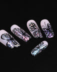 Midnight Monarch irregular shaped handmade press-on nails flat lay on a black background with iridescent butterfly wing designs