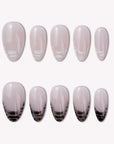 Mist Fade press-on nail set in nude gray with black smoky gradient tips arranged on a white background
