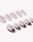 Mist Fade press-on nail set in nude gray with smoky black-and-white tips arranged on a white background