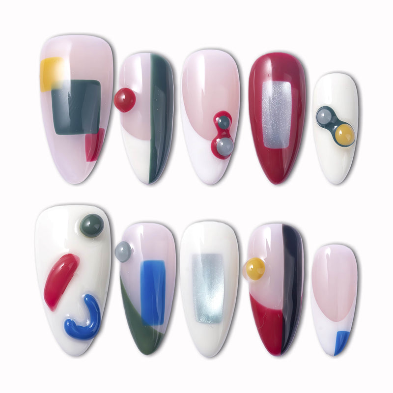 Modernist Dream press-on nails with abstract geometric color blocks, red blue yellow gray accents, raised round details, and glossy nude white bases