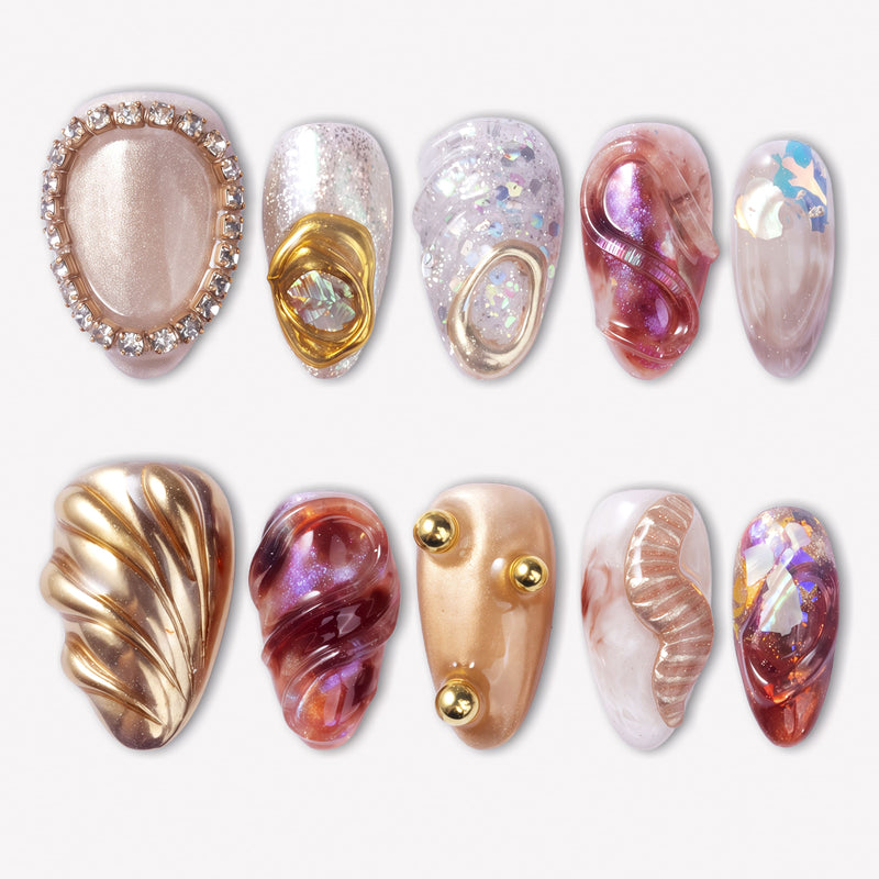 Molten Mirage press-on nails with amber red jelly swirls, champagne shimmer, gold shell accents, rhinestone trim, pearls, and iridescent gems