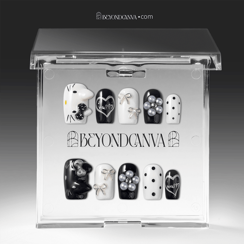 Packaging display of Monochrome Meow press-on nails in a clear BeyondCanva case with black and white cat designs, silver bows, pearl charms, and polka dots