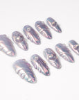Angled flat lay of Moonwave iridescent shell press-on nails with raised wave lines and pearl accents