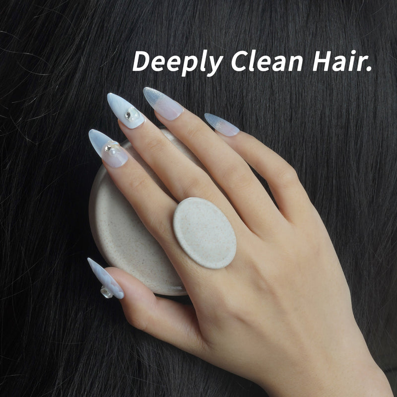 Nail-friendly scalp massager brush used on dark hair by a hand with long blue press-on nails for deep cleansing