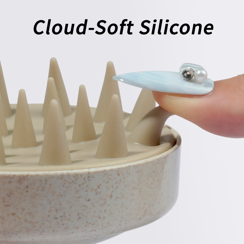 Close-up of cloud-soft cream silicone tips on the nail-friendly scalp massager beside a long blue jeweled nail