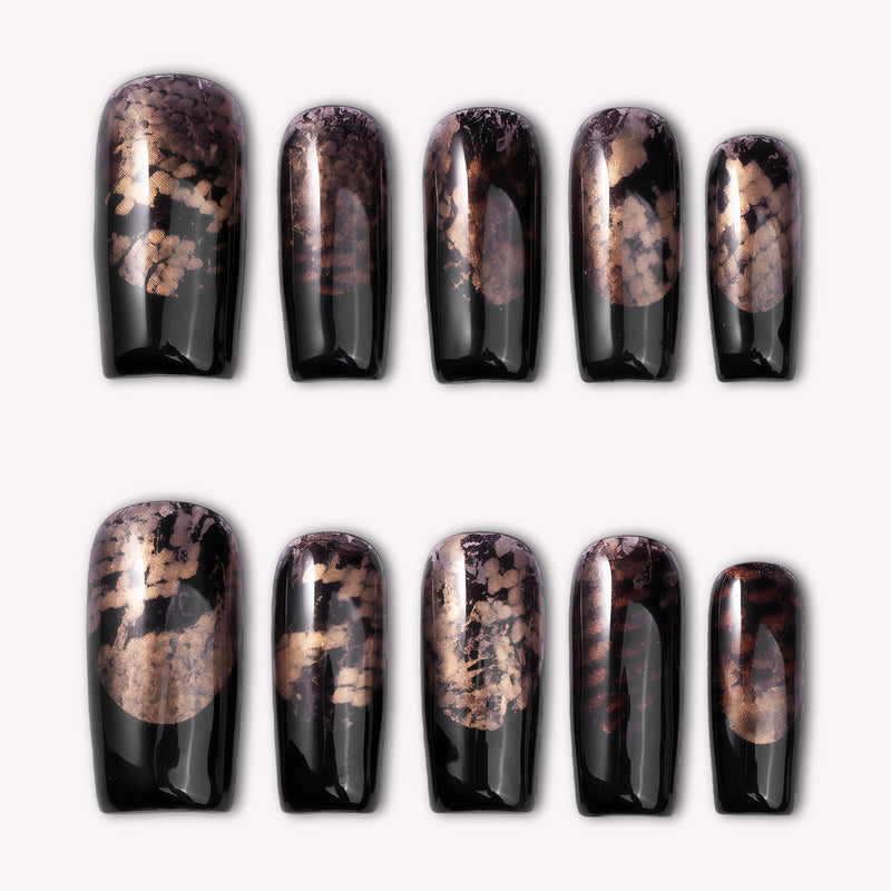 Nocturne Gild press-on nails in glossy black with metallic gold foil accents arranged on a white background