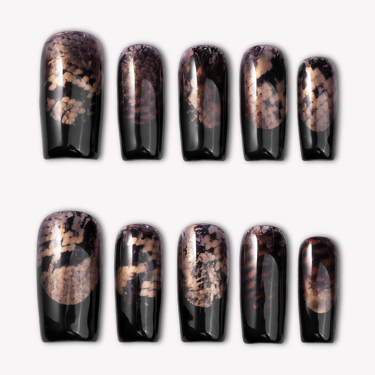 Nocturne Gild press-on nails in glossy black with metallic gold foil accents arranged on a white background