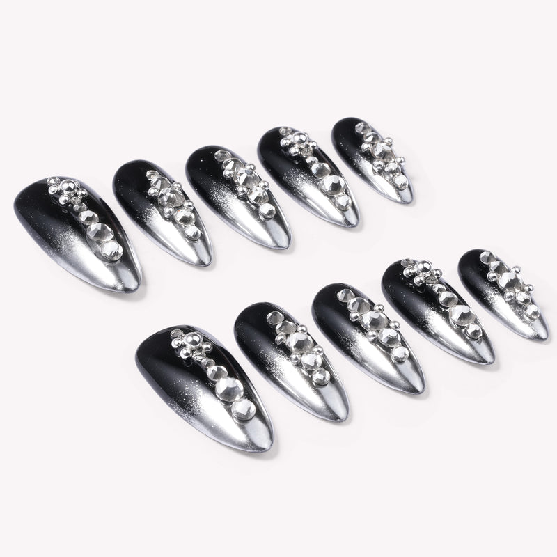 Obsidian Stardust handmade press-on nails flat lay showing black and silver gradient nails with rhinestone accents