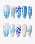 Ocean Rhapsody blue and pearl press-on nails with starfish, shell, jellyfish and wave details in a flat lay